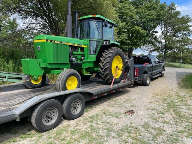 John Deere tractor loaded on a gooseneck trailer