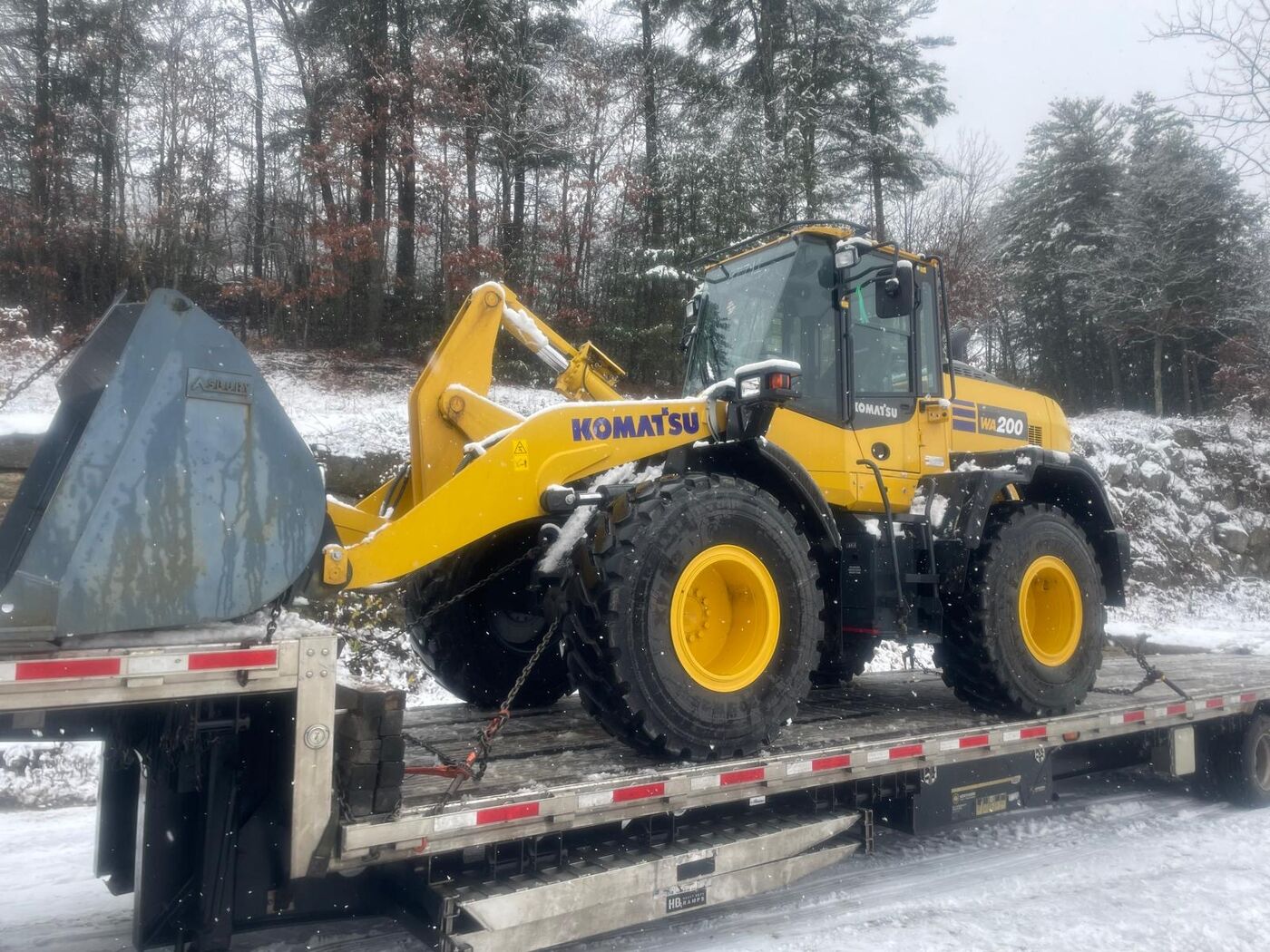 Komatsu wheel loader on a flatbed trailer in the snow