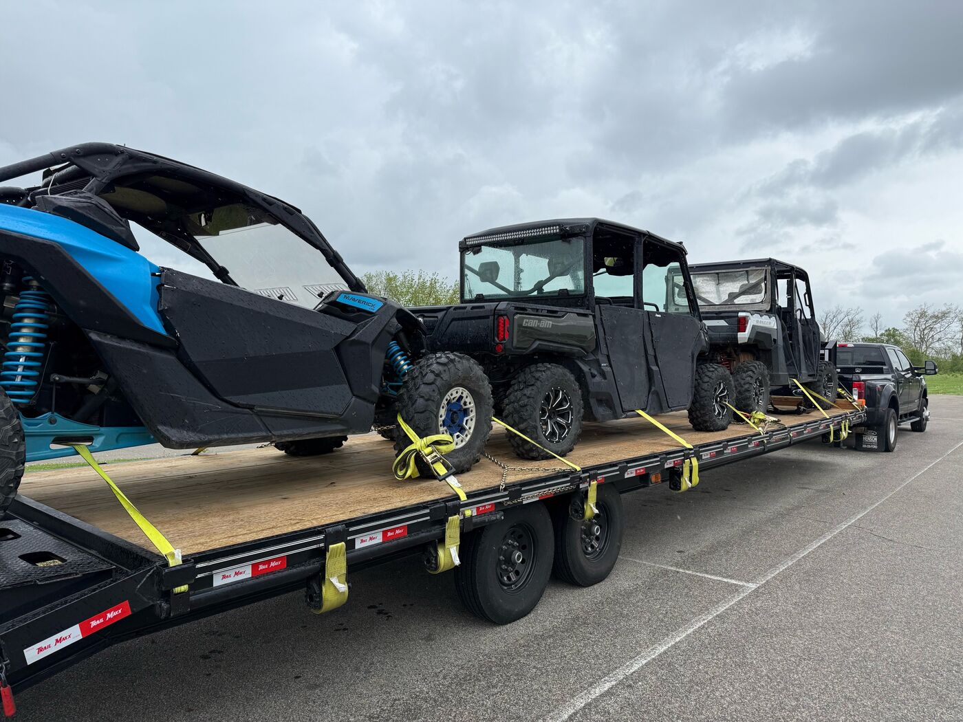 Several UTVs and side-by-sides loaded on a flatbed trailer