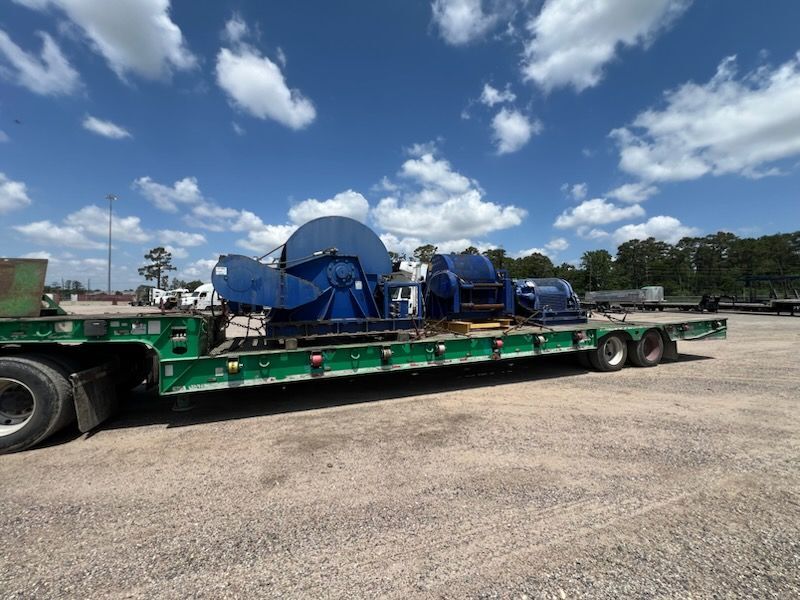 Large industrial winches loaded on a flatbed trailer