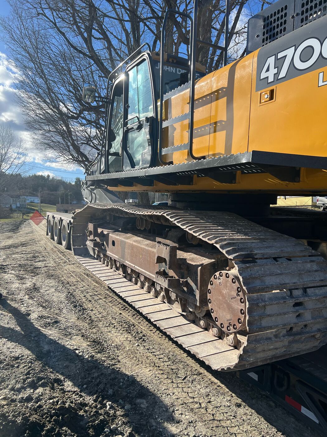 John Deere 470G excavator loaded on a lowboy trailer