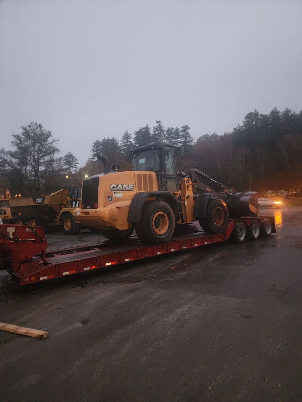 CASE wheel loader loaded on a lowboy trailer at dusk