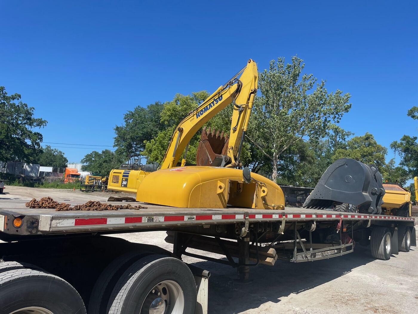 Komatsu PC360 excavator with bucket loaded on a flatbed trailer