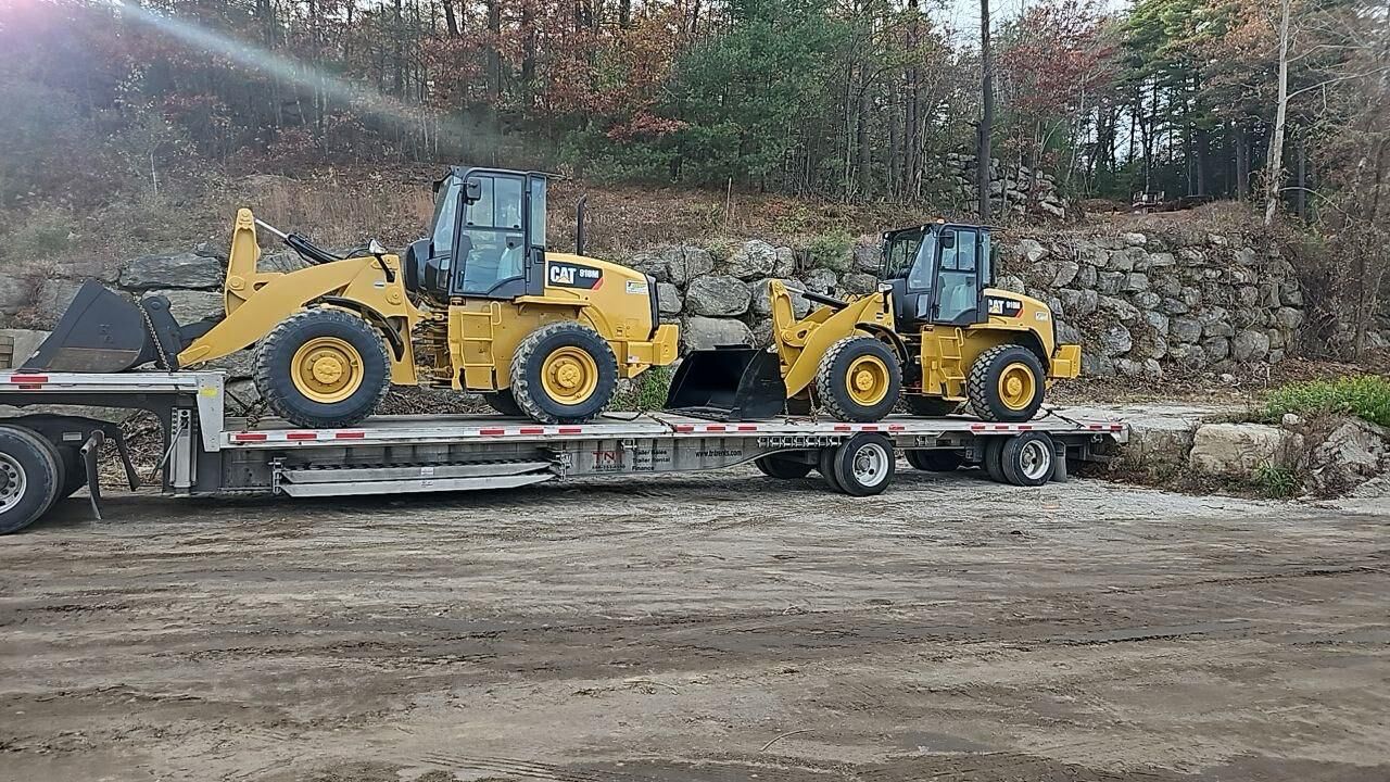 Two CAT compact wheel loaders loaded on a step deck trailer